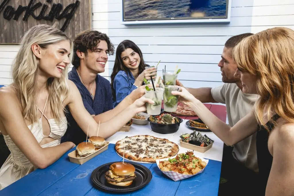 People doing a toast with Mojitos over food